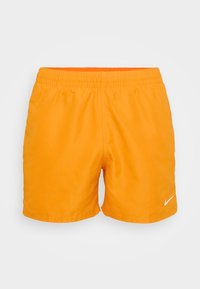 Narancssárga Nike fürdőnadrág rugalmas derékkal, sima textúrával és fehér logóval a jobb alsó oldalon. Zsebek nélkül.