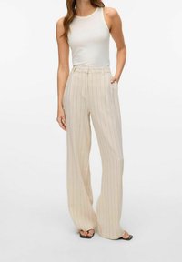 Pantaloni beige a vita alta, a gamba larga, con strisce verticali in colori pastello. Presentano tasche laterali e un aspetto sartoriale.