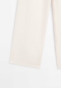 Pantalon beige à jambes larges avec des ourlets propres, présenté à plat sur un fond blanc, montrant un tissu lisse et des coutures droites.
