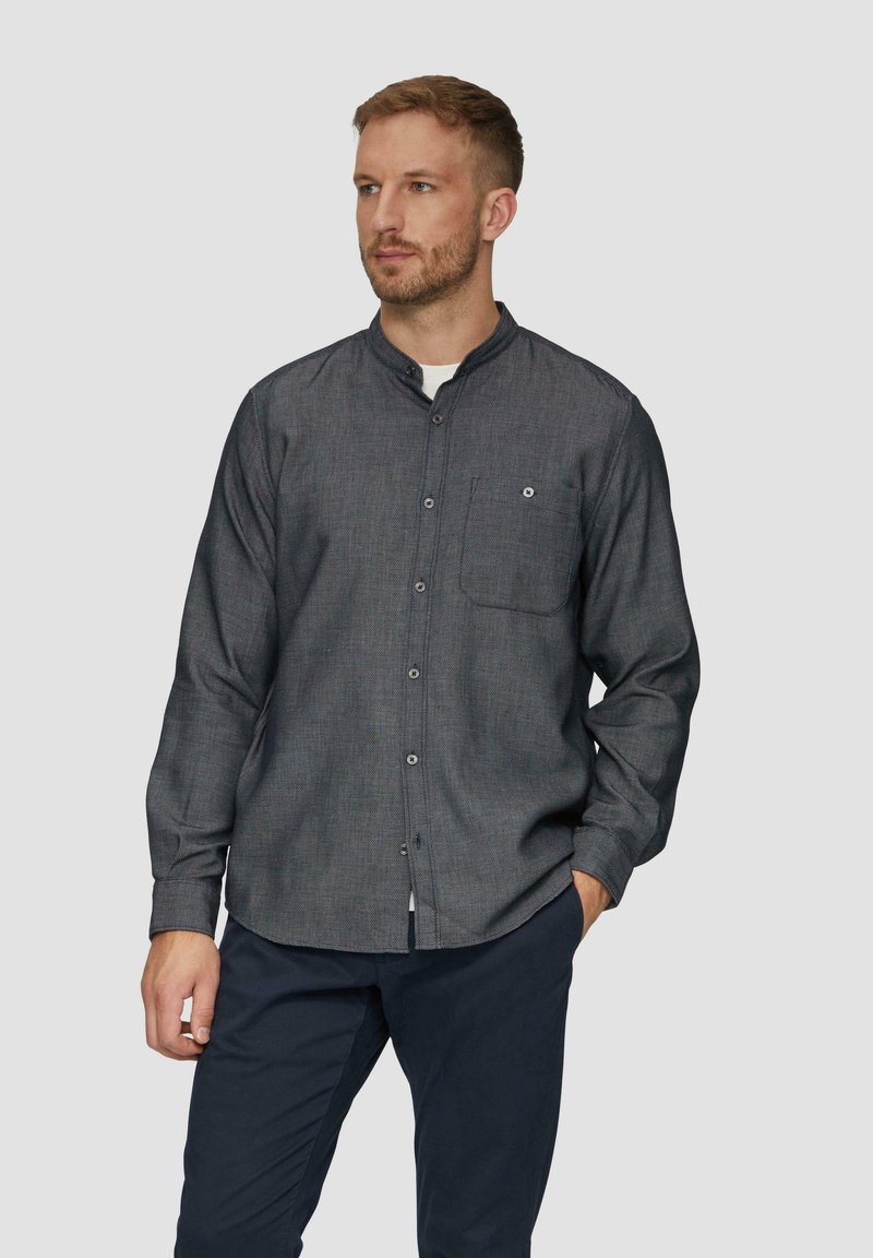 Langarmshirt in donkergrijs met een subtiel patroon, met een button-down kraag, één borstzak en een rechte zoom, gecombineerd met marineblauwe broek.
