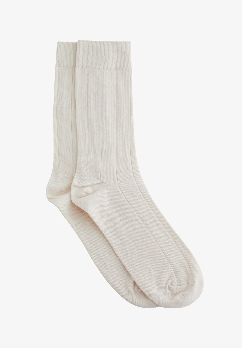 Paire de chaussettes simples côtelées blanc cassé avec bords, présentées à plat et superposées sur un fond blanc.