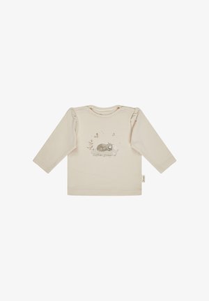 Cream long-sleeved cotton shirt with gathered shoulders, featuring a printed illustration of a sleeping cat, butterflies, and greenery.