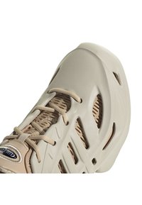 Kermanvärinen urheilukengä, jossa on sileä, muotoiltu päällinen, nauhakiristys, verkko- ja leikatuvarat hengittävyyttä varten.