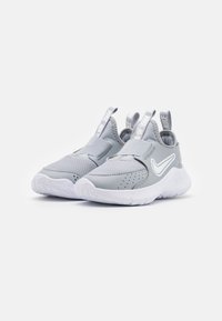 Baskets de sport gris clair en matériau mesh et synthétique, design à enfiler, col rembourré et semelle en caoutchouc blanc avec un motif de traction.