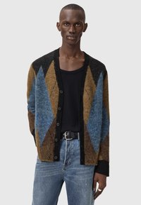 Ζακέτα σε καφέ, μπλε και μαύρο με διαμάντι μοτίβο. Κατασκευασμένη από υφή υλικό, διαθέτει κουμπιά μπροστά και ριμπ μανσέτες.