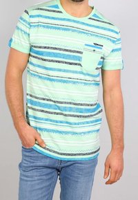 Camiseta de manga corta en verde menta con rayas azules horizontales, que cuenta con un bolsillo en el pecho y patrones texturizados de varios anchos.