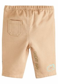 Béžové šortky s elastickým pásom, jednou zadnou vreckom a vyšitým textom "VEĽKÝ DEŇ" s modrým detailom oblaku na ľavej nohe.