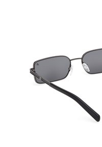 Occhiali da sole rettangolari in metallo nero con lenti grigio scuro, naselli regolabili e sottili aste nere su sfondo bianco.