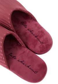 Teksturowane, bordowe kapcie z miękką, pluszową wkładką. Z zewnątrz w paski oraz z haftowanym napisem "latte checkout" wewnątrz.