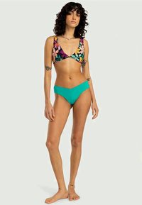 Top de bikini floral colorido com copas triangulares e alças finas, combinado com um fundo de bikini sólido em turquesa de cintura média. Textura de tecido suave.