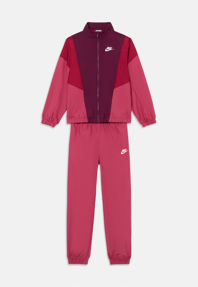Nike trenirka u nijansama ružičaste i burgundske, sa zipanjem jaknom dugih rukava i odgovarajućim hlačama s elastičnim pojasom. Istaknuti logotip.