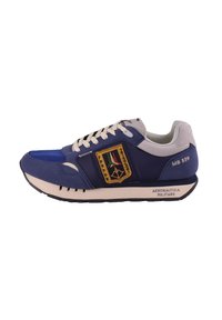 Sneaker blu navy e grigio chiaro con superior in tessuto texturizzato, accenti beige, un emblema colorato e una suola in gomma con un motivo a righe.
