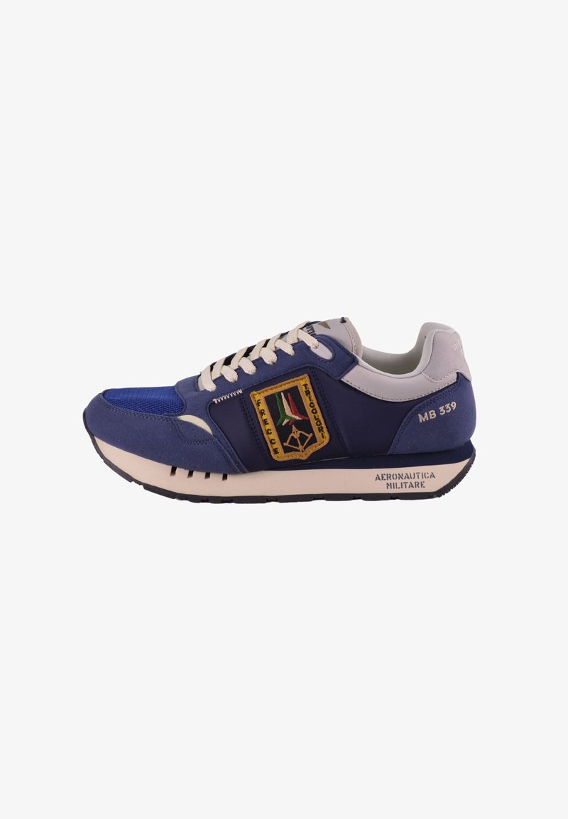 Sneaker blu navy e grigio chiaro con superior in tessuto texturizzato, accenti beige, un emblema colorato e una suola in gomma con un motivo a righe.