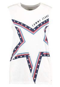 Valkoinen hihaton T-paita, jossa on suuri sininen ja punainen tähden kuvasto valkoisilla tähdillä ja "TOMMY JEANS" -teksti yläpuolella. Puuvillamateriaali.