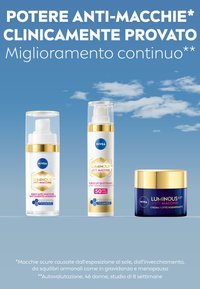 Tre prodotti per la cura della pelle NIVEA: un siero in una bottiglia trasparente, un fluido UV in una bottiglia bianca con dettagli dorati e un barattolo di crema notturna blu.