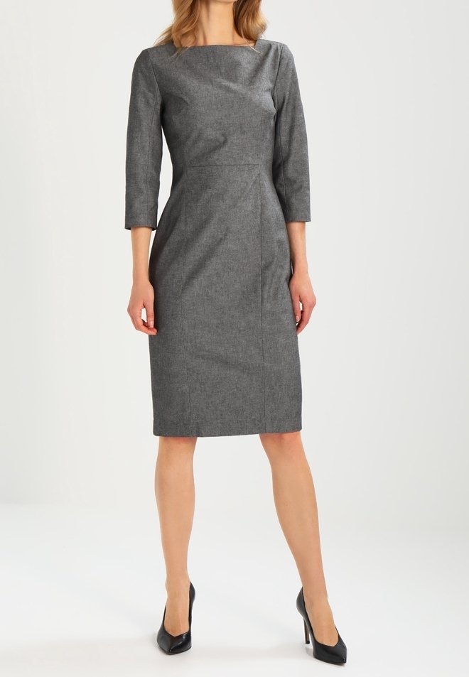 Grå figurnära klänning med trekvartslånga ärmar, båtformad halsringning och skräddarsydda sömmar. Bärs med svarta högklackade skor. Slät textur, knälång.