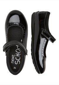 Scarpe in pelle verniciata nera con design Mary Jane, dotate di una fascia e dettagli perforati nell'area delle dita. Soletta con texture.