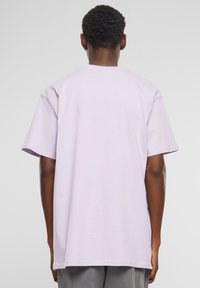 Light purple t-shirt with short sleeves, relaxed fit, and a round neckline. Soft fabric, smooth texture, and no visible patterns or graphics.