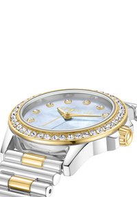 Sudrabota un zelta krāsā pulkstenis ar apaļu seju, mātes pērļu ciparnīcu, kristāla akcentiem un savienotu siksniņu. Zelta stundu marķieri.