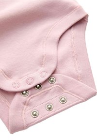 Body de algodón color rosa claro con cierres a presión en la parte inferior, que presenta una textura suave y botones metálicos en contraste en la apertura.