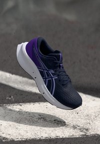 Dark blue athletic shoe featuring a breathable mesh upper, purple accents, white sole, and decorative stripes on the side.