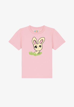 Roze katoenen t-shirt met een cartoon konijnontwerp met grote ogen en lange oren, gelegen boven groene gras. Korte mouwen en ronde hals.