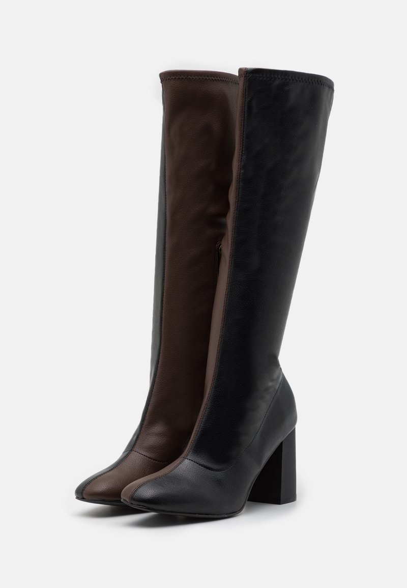 Stiefel bis zum Knie mit einem gespaltenen Design, aus schwarzem und braunem Leder, mit spitzen Zehen und einem Blockabsatz. Elegante Verarbeitung mit subtilen Nähten.