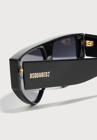 Μαύρα ορθογώνια γυαλιά ηλίου με σκούρους φακούς και τη λέξη «DSQUARED2» σε χρυσά γράμματα στη φαρδιά βραχίονα του σκελετού.