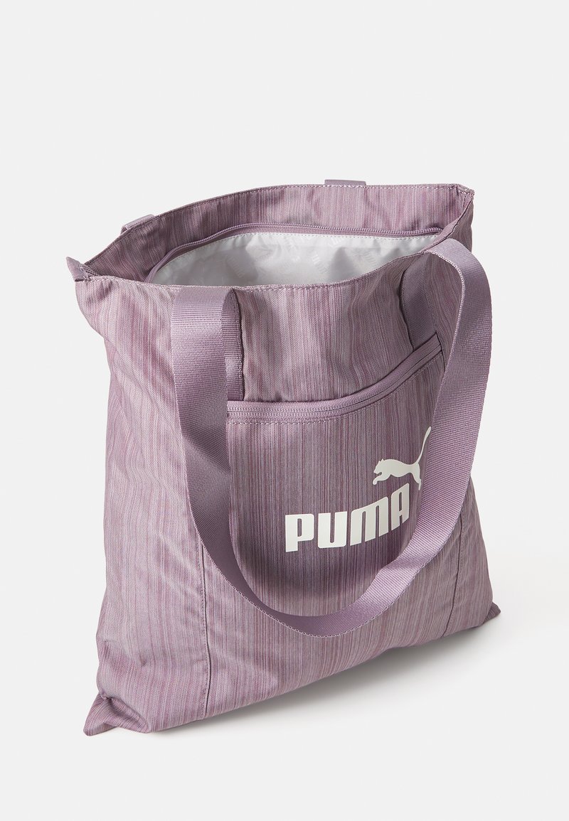 Borsa a spalla viola con strisce verticali, dotata di una tasca frontale, manici robusti e un logo Puma bianco. L'interno è foderato in argento.