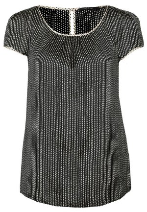 Blouse noire à manches courtes avec des rayures verticales blanches en pointillés, col rond et bordure claire le long du col et des manches.