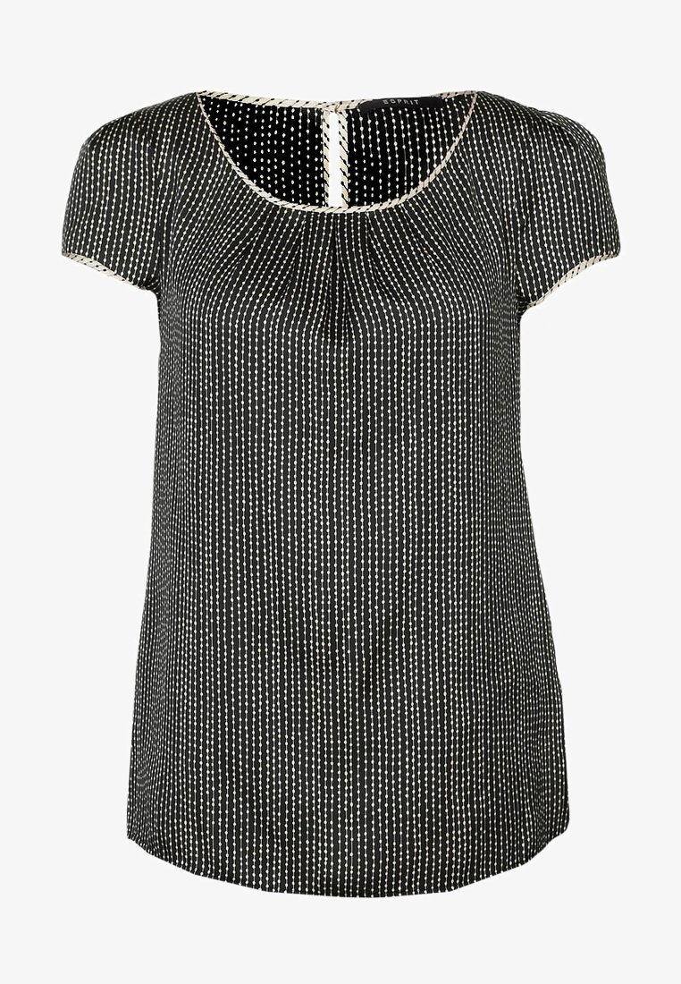 Blouse noire à manches courtes avec des rayures verticales blanches en pointillés, col rond et bordure claire le long du col et des manches.