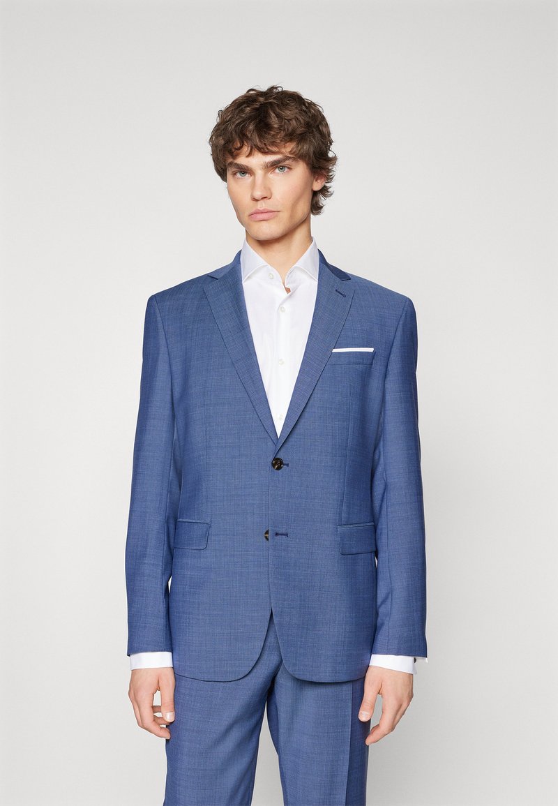 Blauw patteren jasje met notch revers, twee voordoekjes en een enkele knoopsluiting. Draag het over een witte overhemd met kraag.