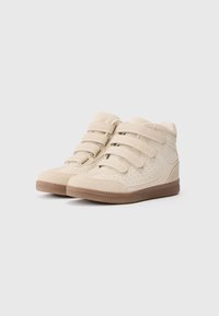 Μπεζ ψηλές αθλητικές μποτούλες με διάτρητες λεπτομέρειες, τρεις λωρίδες με αυτοκόλλητο κλείσιμο και καφέ καουτσούκ σόλα. Σατινέ και υφασματικές υφές.