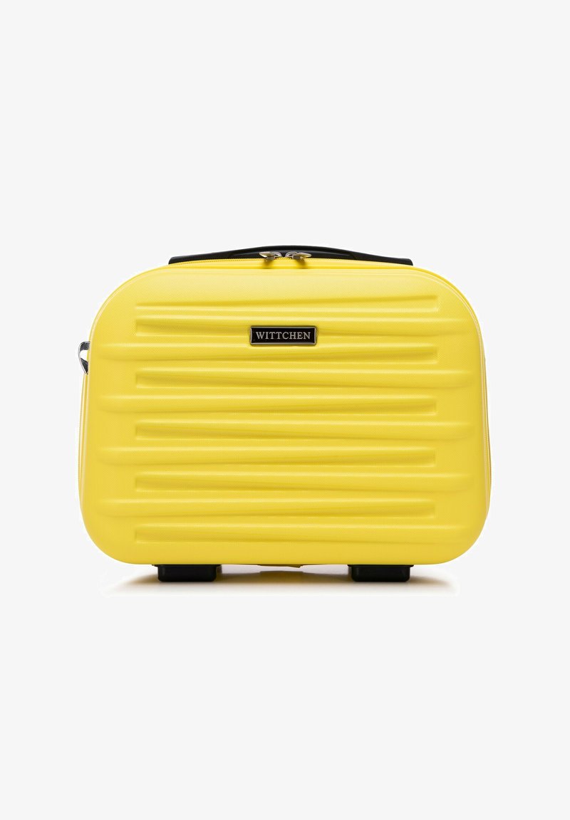 Estuche de cosméticos rígido amarillo con estrías horizontales, cremallera negra y placa con logotipo. Diseño compacto y rectangular con patas en la parte inferior para mayor estabilidad.