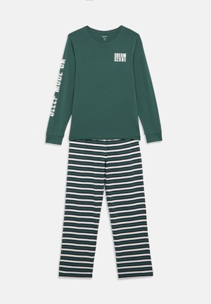 Conjunto de camiseta de manga longa verde com o texto "DREAM ZONE" e calças de pijama listradas em verde, branco e preto, sobre fundo branco.