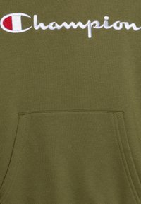 Felpa con cappuccio verde oliva con tasca frontale. Presenta il logo "Champion" ricamato in bianco e rosso. Texture morbida, design casual.