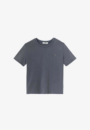 T-shirt en coton gris avec un col rond, des manches courtes et un petit emblème en forme de cœur sur la poitrine. Texture lisse, coupe décontractée.