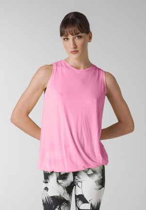 Lyserød ærmeløs top lavet af letvægtsstof, med en rund halsudskæring og en afslappet pasform, parret med sort-hvide mønstrede leggings.