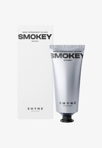 Półtrwały błyszczyk w srebrnej tubce z czarną nakrętką, oznaczony napisem "SMOKEY BROWN", obok białego pudełka z czarnym tekstem.
