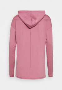 Długa bluza z kapturem w miękkim różowym kolorze. Posiada luźny krój, regulowany kaptur oraz przeszycia po bokach. Gładka faktura, minimalizm w designie.