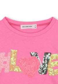 Roze t-shirt met ronde halslijn, versierd met meerkleurige sequins in de tekst "#Love" en een hartontwerp. Label leest "BILLIEBLUSH", maat 6.