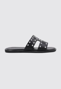 Chanclas negras de suela plana, con dos tiras anchas decoradas con tachuelas plateadas en la parte superior. Fabricadas en material sintético.