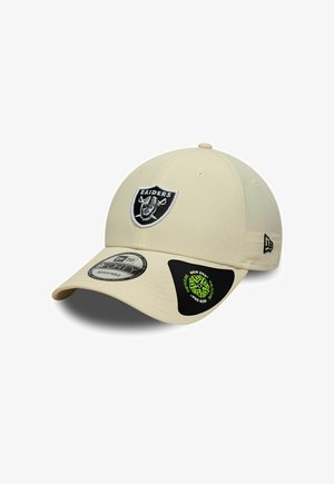 Gorra de béisbol beige ajustable con parche del logo de los Raiders en blanco y negro en el frente, y branding de New Era en el lateral y pegatinas en la visera.