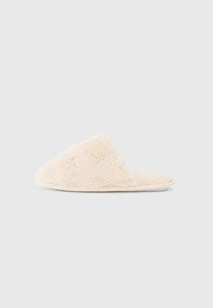 Fuzzy, cremefarvet sutsko med en blød tekstur, åben tå-design og subtile broderede detaljer på den øverste side.