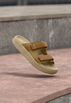 Sandalo alla schiava color sabbia con due cinturini regolabili, suola in gomma e plantare testurizzato. Design minimalista, adatto per un abbigliamento casual.