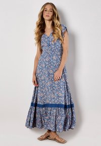 Robe maxi florale bleue à manches courtes, dotée d'une taille froncée, d'une jupe évasée et de contours en dentelle bleu contrastant à l'ourlet.