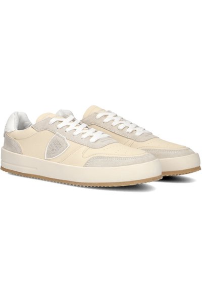 Beige atletik sko med en glat læder- og ruskindsoverdel, hvide snørebånd og en struktureret sål. Har en diskret logo detalje på siden.