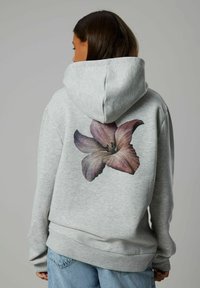 Felpa con cappuccio grigia realizzata in tessuto morbido, presentante una grande grafica floreale in tonalità di rosa e viola sul retro.