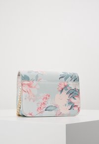 Blumenmuster Geldbörse aus hellblauem Kunstleder. Verfügt über einen Kettenriemen, rechteckige Form und eine weiche Textur mit pinken und grünen Akzenten.