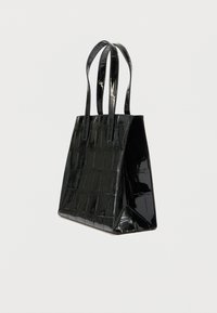 Svart håndveske i lakklær med en teksturert, krokodillelignende mønster. Har to lange håndtak og en strukturert, rektangulær form.
